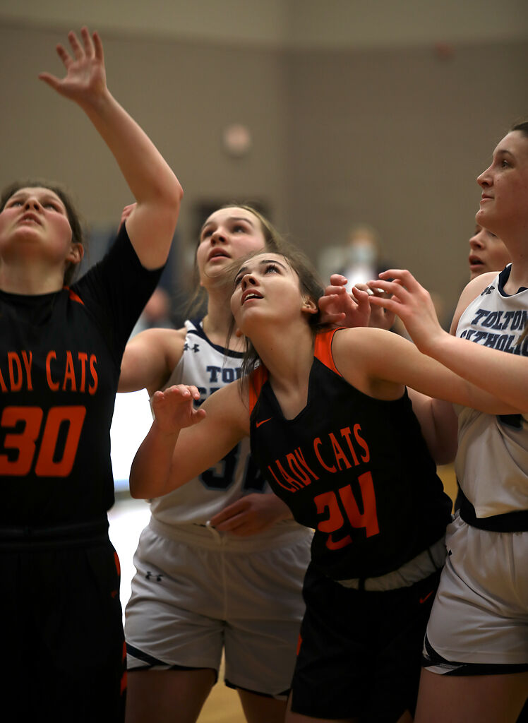 Players watch the basketball go into the hoop